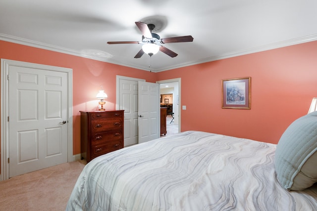 carpeted bedroom with ornamental molding and ceiling fan