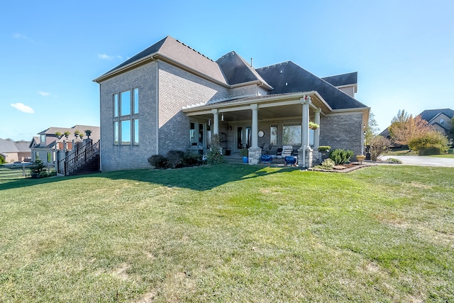 back of house featuring a lawn and a patio area