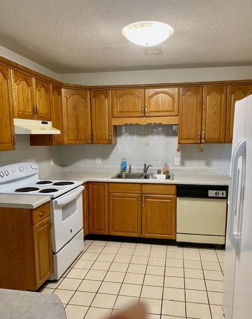 kitchen featuring light tile patterned flooring, a textured ceiling, decorative light fixtures, and kitchen peninsula