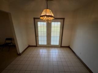 empty room featuring light tile patterned floors and a notable chandelier