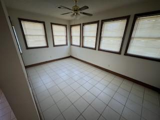 unfurnished sunroom featuring ceiling fan