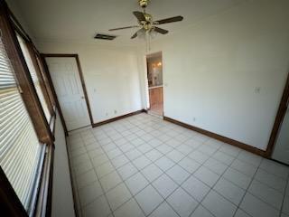 unfurnished bedroom with light tile patterned flooring and ceiling fan