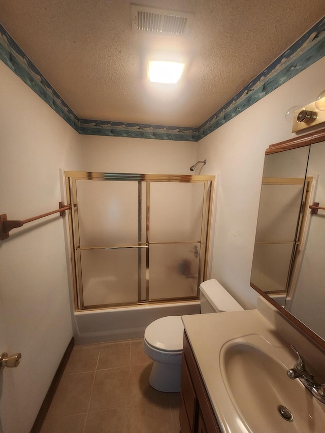 full bathroom featuring vanity, a textured ceiling, toilet, enclosed tub / shower combo, and tile patterned floors