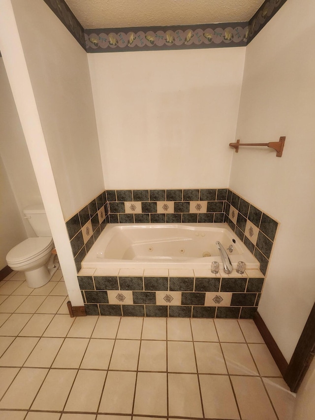 bathroom featuring tile patterned flooring, a relaxing tiled tub, toilet, and a textured ceiling