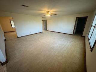 carpeted spare room featuring ceiling fan