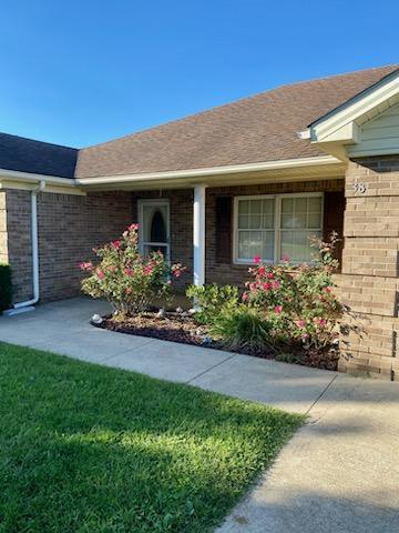 doorway to property with a lawn