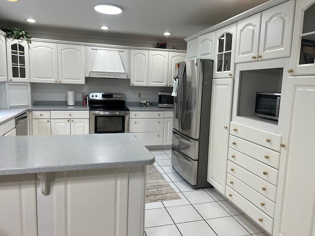 kitchen with light tile patterned floors, white cabinets, glass insert cabinets, custom exhaust hood, and stainless steel appliances