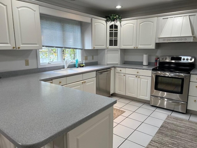 kitchen with custom exhaust hood, light tile patterned floors, appliances with stainless steel finishes, white cabinetry, and a sink