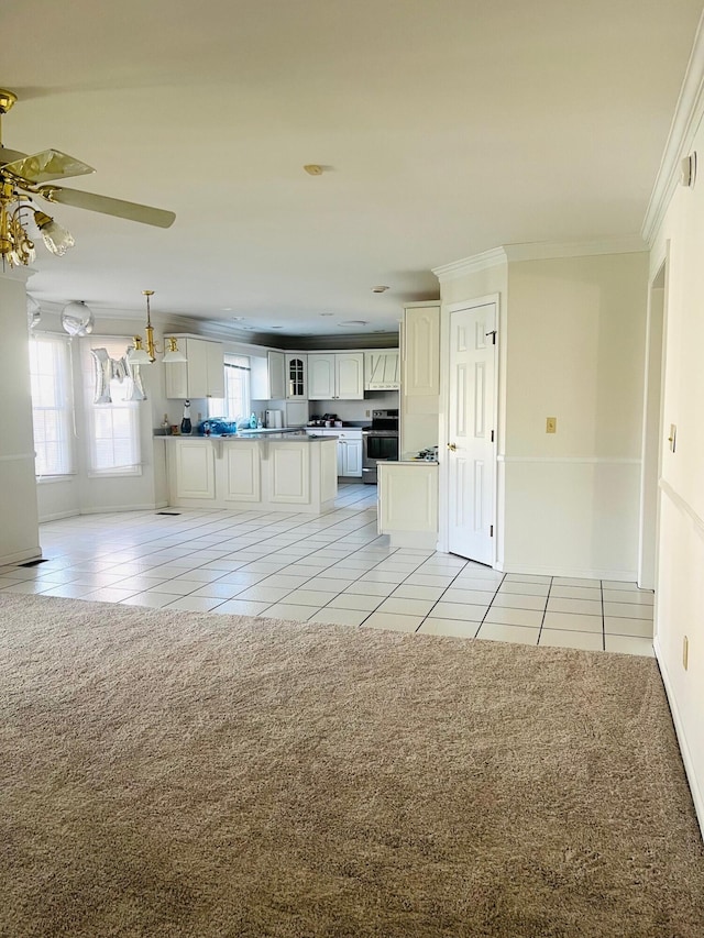 kitchen with stainless steel range with electric stovetop, light tile patterned floors, white cabinetry, and crown molding