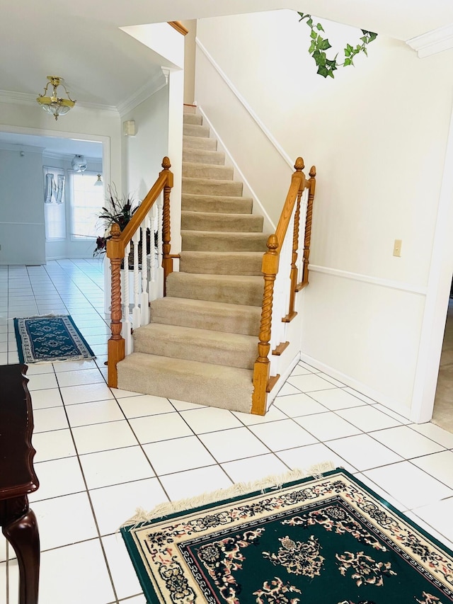 staircase with ornamental molding and tile patterned flooring