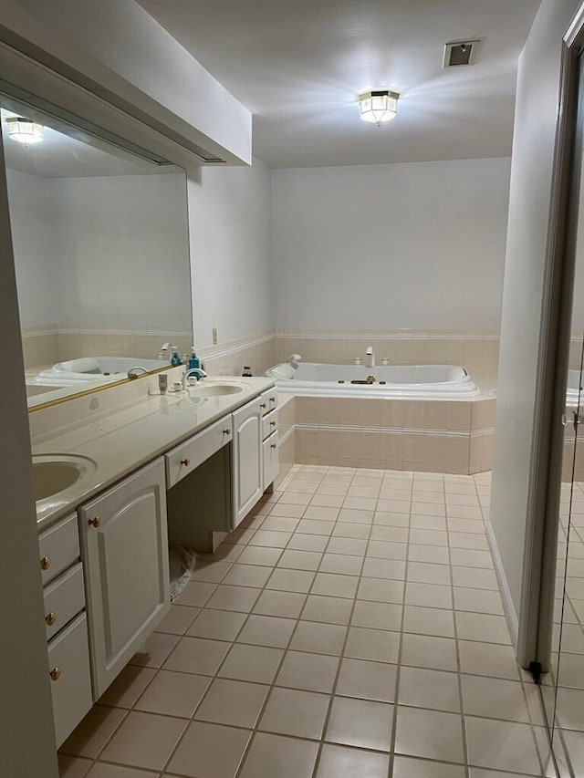 bathroom with a garden tub, a sink, visible vents, and tile patterned floors