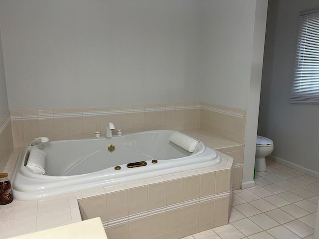 bathroom with baseboards, a garden tub, toilet, and tile patterned floors