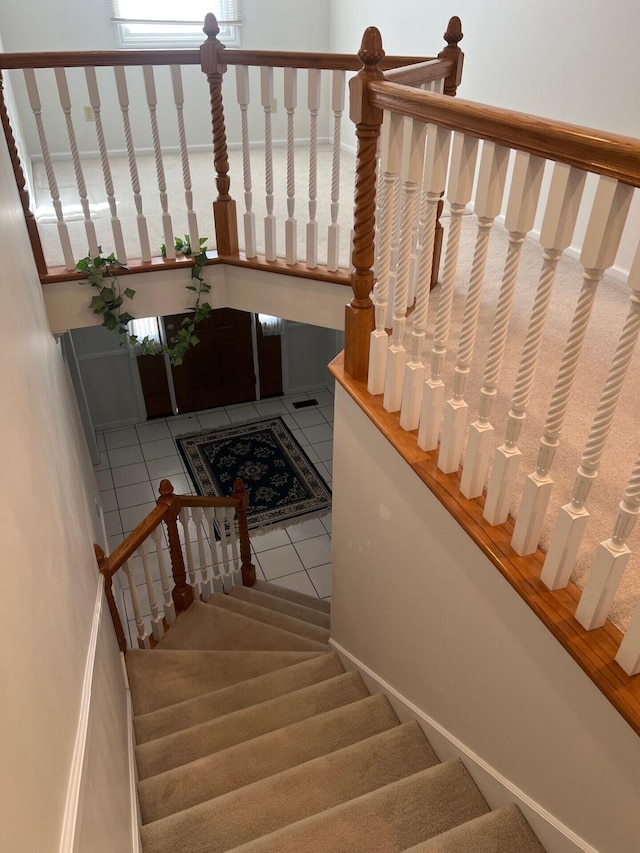 stairs with a water view and tile patterned floors