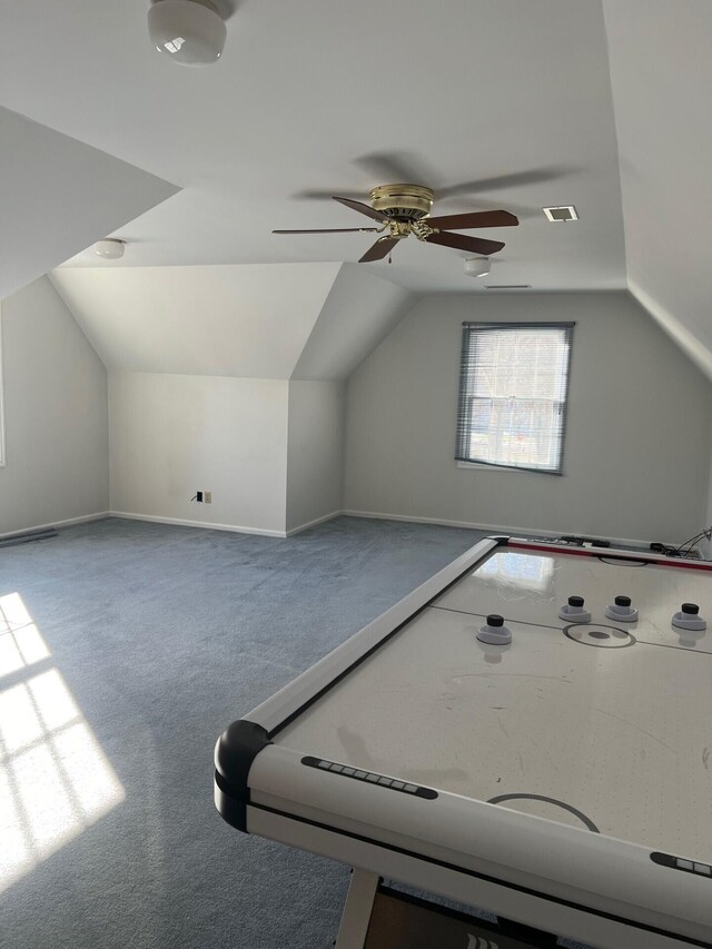 rec room with carpet floors, visible vents, vaulted ceiling, and a ceiling fan