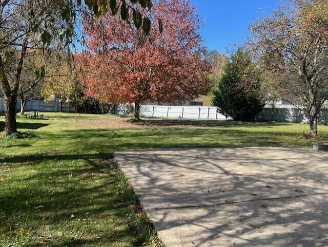 view of community with fence and a yard