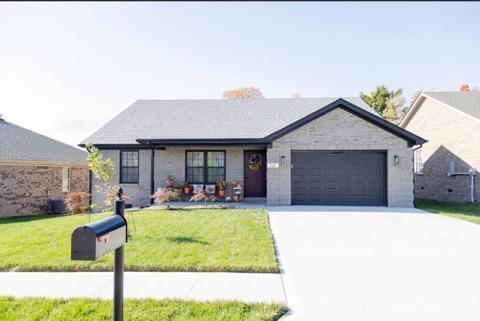 view of front of home with a front yard and a garage