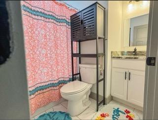 bathroom featuring vanity, toilet, tile patterned flooring, and a shower with shower curtain