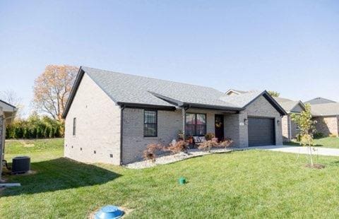 view of front of property featuring a front lawn and a garage