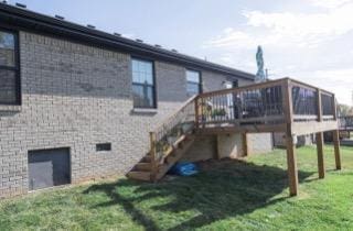 back of property featuring a yard and a deck