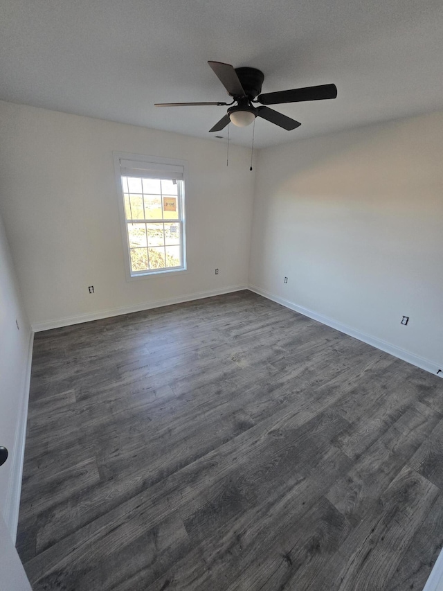 spare room with dark hardwood / wood-style floors and ceiling fan