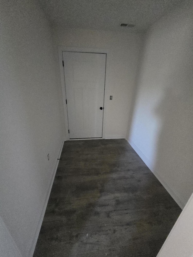 corridor with dark hardwood / wood-style flooring