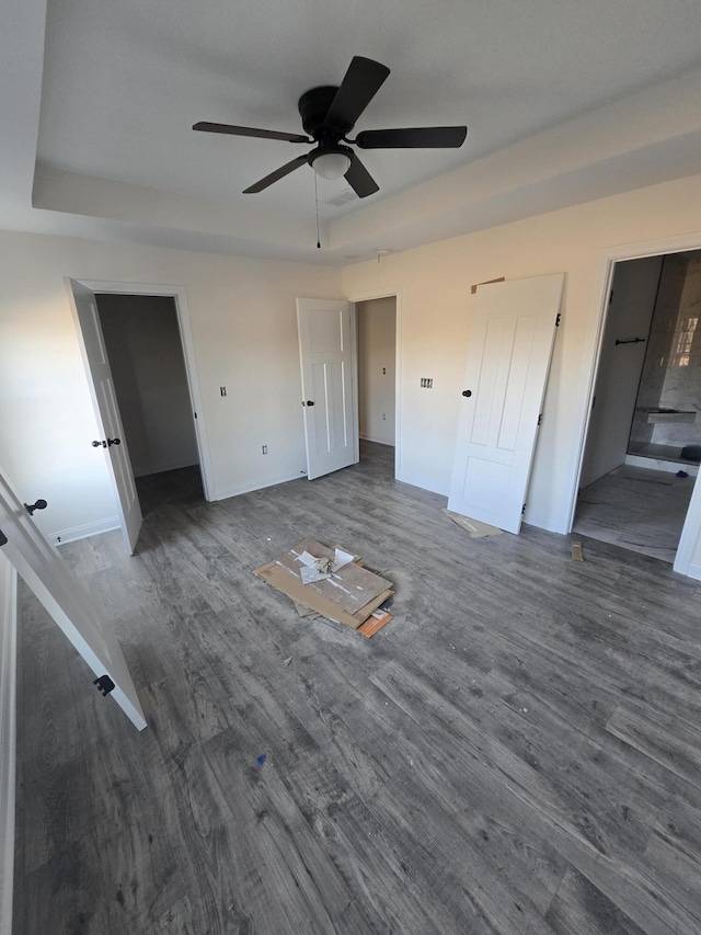 unfurnished bedroom featuring dark wood-type flooring, connected bathroom, and ceiling fan