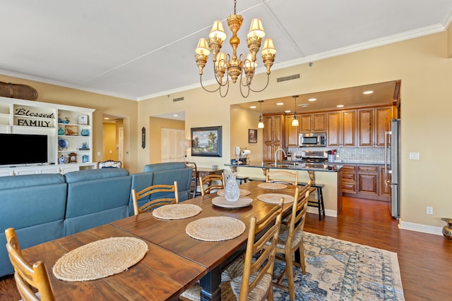 dining room featuring dark hardwood / wood-style floors, ornamental molding, sink, and a chandelier