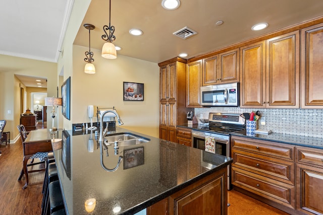 kitchen with sink, crown molding, dark hardwood / wood-style floors, decorative light fixtures, and stainless steel appliances