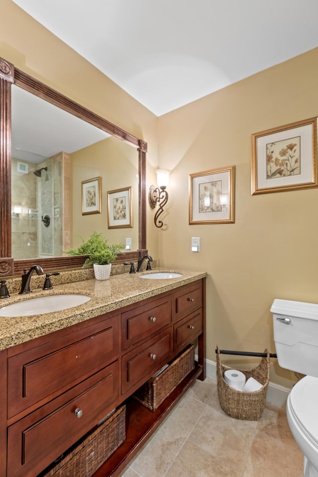 bathroom featuring tile patterned flooring, vanity, toilet, and an enclosed shower