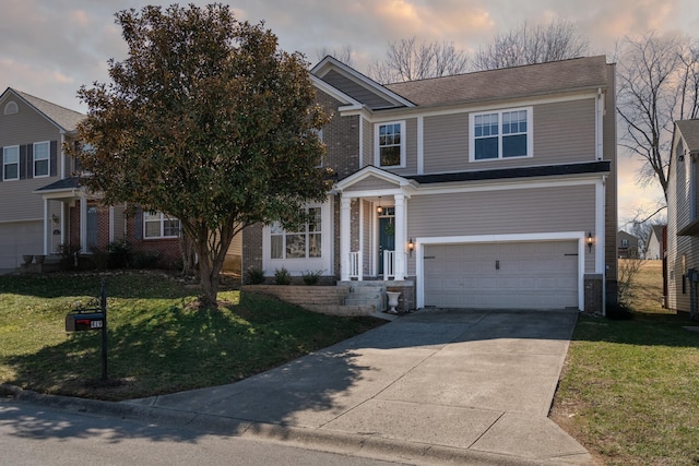 traditional home featuring brick siding, a lawn, an attached garage, and driveway