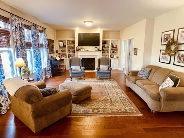 living room featuring built in features, plenty of natural light, and wood-type flooring