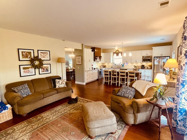 living room with a chandelier and dark hardwood / wood-style floors