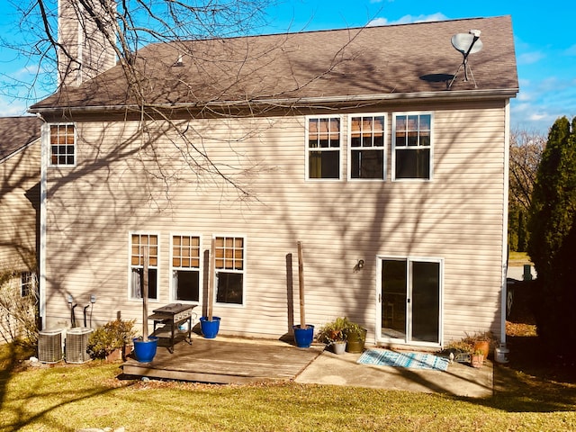 back of property with a wooden deck, a lawn, and central air condition unit