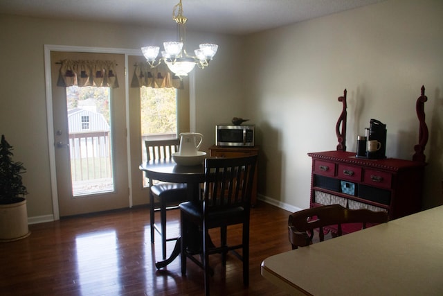 dining area featuring a notable chandelier and dark hardwood / wood-style floors