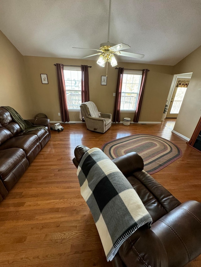 living room with ceiling fan, light hardwood / wood-style floors, a textured ceiling, and a healthy amount of sunlight