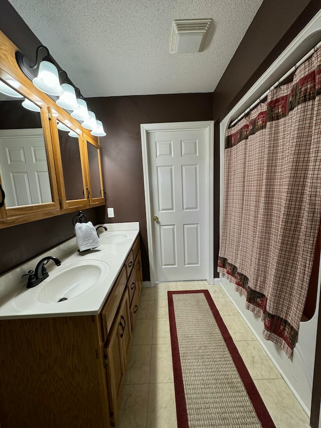 bathroom featuring vanity, a textured ceiling, tile patterned floors, and a shower with curtain