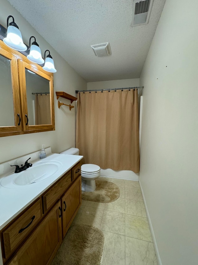 bathroom with toilet, vanity, a textured ceiling, and tile patterned floors