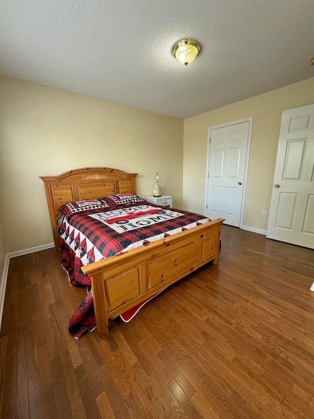 bedroom with dark wood-type flooring and a textured ceiling