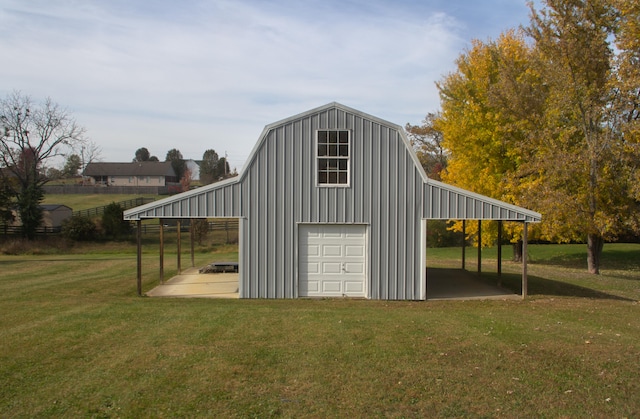 view of outdoor structure featuring a lawn, a carport, and a garage