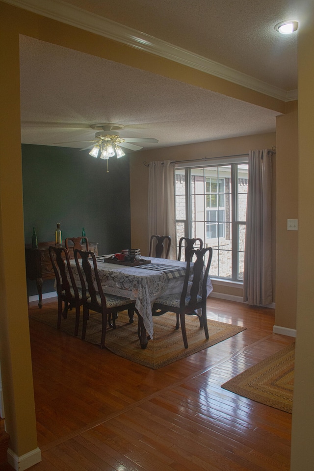 dining space with ornamental molding, a textured ceiling, hardwood / wood-style flooring, and ceiling fan