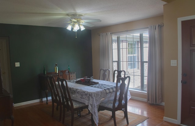 dining room with a textured ceiling, wood-type flooring, and ceiling fan