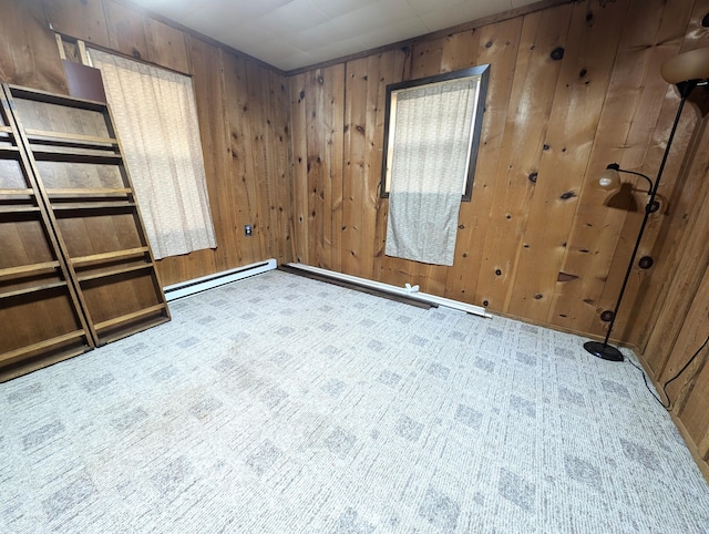 carpeted empty room featuring a baseboard radiator and wooden walls