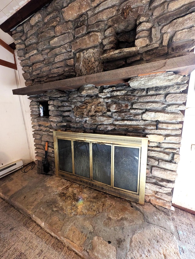 room details with a baseboard heating unit and a stone fireplace