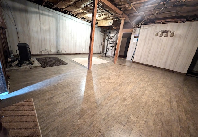 basement featuring hardwood / wood-style floors and wooden walls