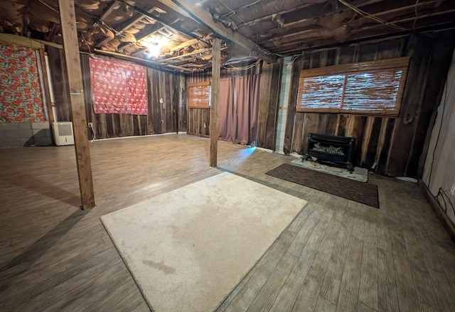 basement featuring a wood stove and hardwood / wood-style flooring