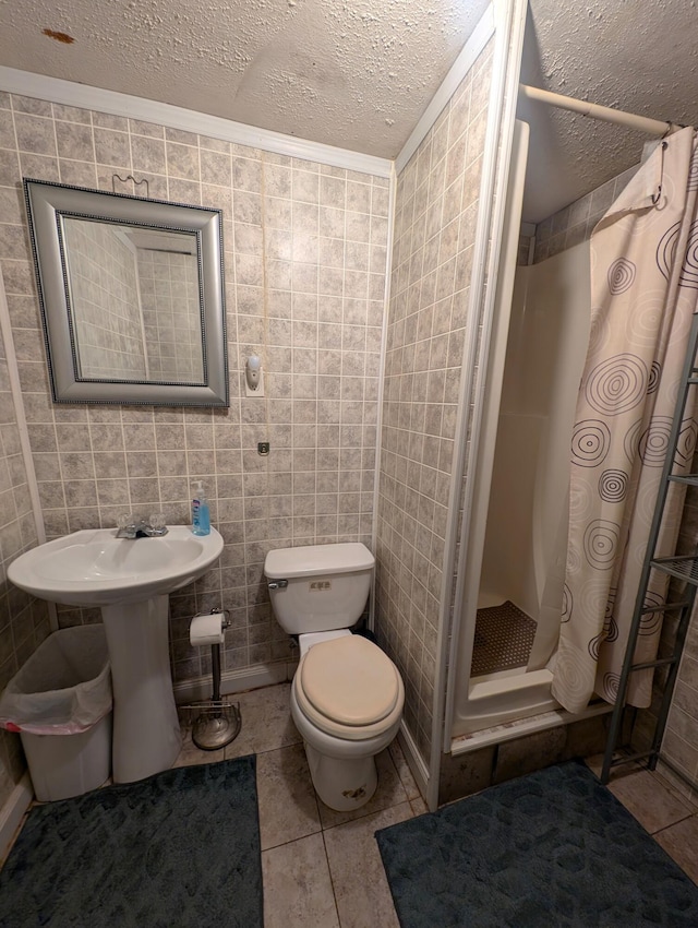 bathroom featuring toilet, tile patterned flooring, a shower with curtain, tile walls, and a textured ceiling