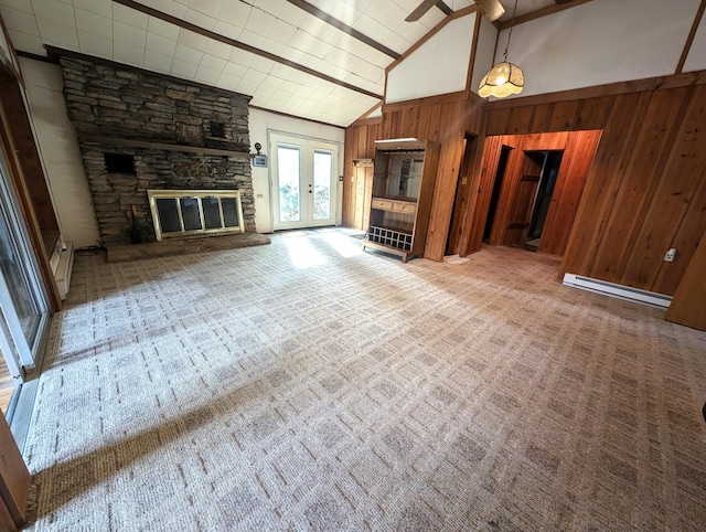 unfurnished living room with a baseboard heating unit, a stone fireplace, beamed ceiling, high vaulted ceiling, and light colored carpet