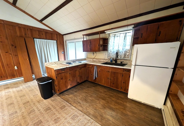 kitchen featuring dark hardwood / wood-style flooring, vaulted ceiling with beams, wood walls, sink, and white appliances