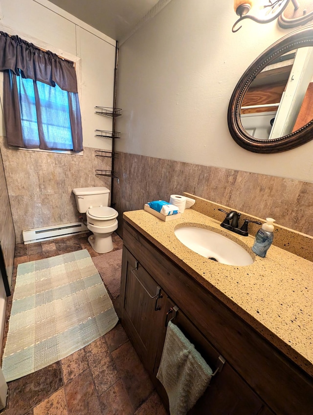 bathroom with vanity, toilet, tile walls, and a baseboard radiator