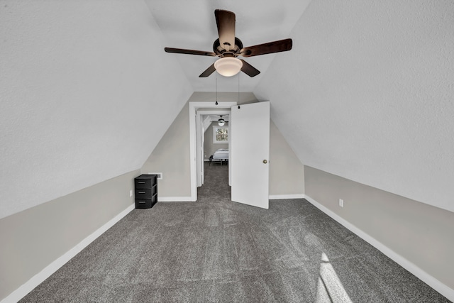 bonus room with lofted ceiling, a textured ceiling, ceiling fan, and dark colored carpet